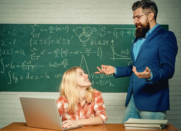 Onderwijs. Leraar helpt jonge student met de les. Bijles geven. Leerling en leraar zitten aan een bureau in de klas. Universiteitsseminar. Klaar voor school. Studenten die zich voorbereiden op universitaire examens. — Stockfoto