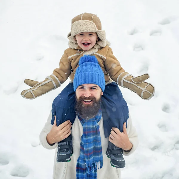 아버지는 아들을 데리고 공원으로 돌아갔다. 메리 크리스마스, 새해 복 많이 받으세요. 아들에게 등받이를 어깨에 메고 올려다보는 행복 한 아버지의 모습. — 스톡 사진