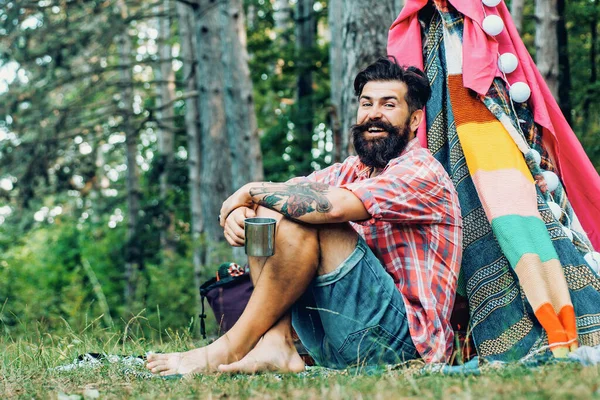 阳光灿烂的日子搭帐篷.有胡子的男人在小木屋里旅游业依靠自然.关于自然的夏令营. — 图库照片
