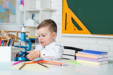 Çocuk sınıfta tahtayla ilgili bir şeyler öğreniyor. Okul çocukları. Ev uzaklığı öğrenimi.