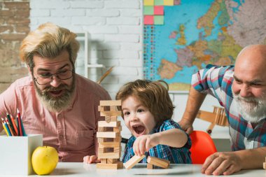 Mutlu küçük çocuk baba ve büyükanne ve büyükbaba eğlence zamanı. Mutlu çok nesilli aile evde Jenga oynuyor..