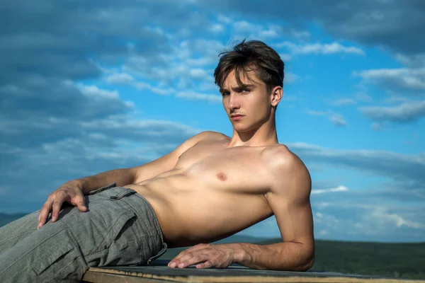 Modelo masculino musculoso sin camisa en la naturaleza del cielo. — Foto de Stock