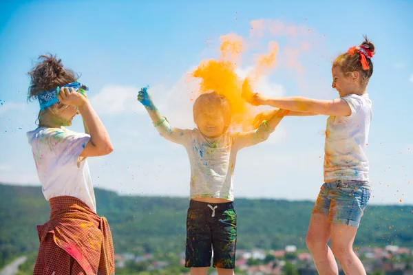 Kinder spielen mit Holi-Farbpuder. Kinder feiern Holi-Fest der Farben. Farbspritzer Spiel. — Stockfoto