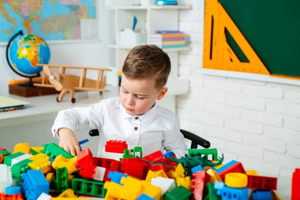 Kinderen vroege ontwikkeling. Kleuterjongen met educatief speelgoed - blokken, trein, spoorweg, vliegtuig. Kind van de basisschool. — Stockfoto