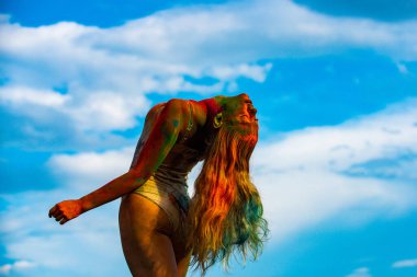 Vücuduna renkli bir vadi sıçramış. Holi boya partisindeki neşeli genç kadın..