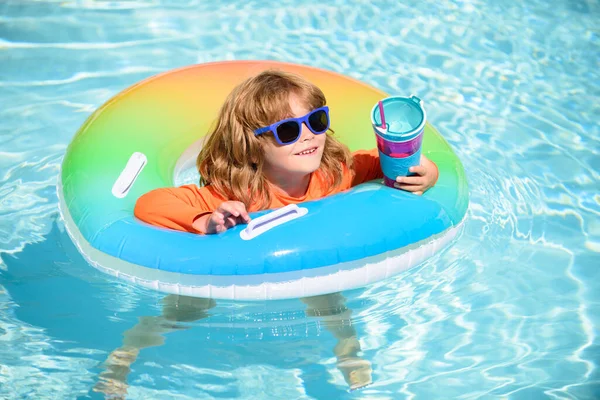 O miúdo a brincar na água azul. Criança feliz brincando com anel de natação colorido na piscina no verão. As crianças brincam em resort tropical. Família praia férias. — Fotografia de Stock