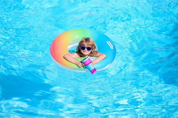 Enfant heureux jouant avec anneau de natation coloré dans la piscine le jour d'été. Jouets d'eau pour enfants. Les enfants jouent dans une station tropicale. Vacances familiales à la plage. — Photo