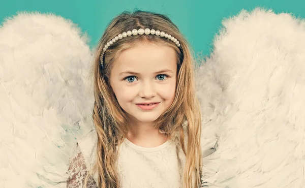 Gadis kecil pirang yang cantik dalam gambar malaikat dengan sayap putih. Anak malaikat dengan rambut keriting pirang. Malaikat. Indah anak malaikat berpose dan melihat kamera. — Stok Foto