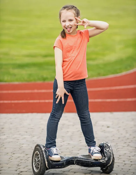 Kleine Mädchen hoverboarden in Parks. Lustiges Mädchen. Sorgenfreies Kind. Kleines Kind genießt Spaziergang. — Stockfoto