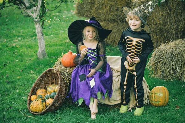 Boldog Halloweent! A gyermekbarátság, a béke, a kedvesség, a gyermekkor fogalma. Halloween gyerekek élvezik az őszi parkban a pályán. — Stock Fotó