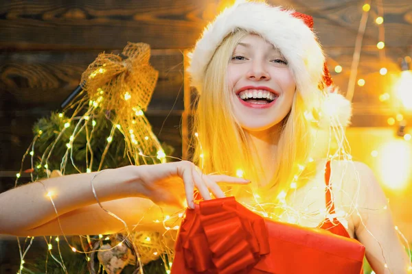 Frohe Weihnachten lächelndes Mädchen mit Weihnachtsgeschenkbox. Konzept der Ferien. Sexy Frau mit Weihnachtsmütze. — Stockfoto