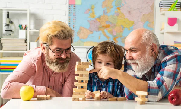 幸せな男の家族の概念を笑うと一緒にお楽しみください。祖父は息子と孫を見てボードゲームを自宅で. — ストック写真