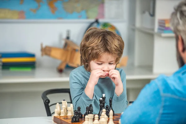 Dítě hraje šachy - vzdělávací hry. Chlapec hraje doma šachy. — Stock fotografie