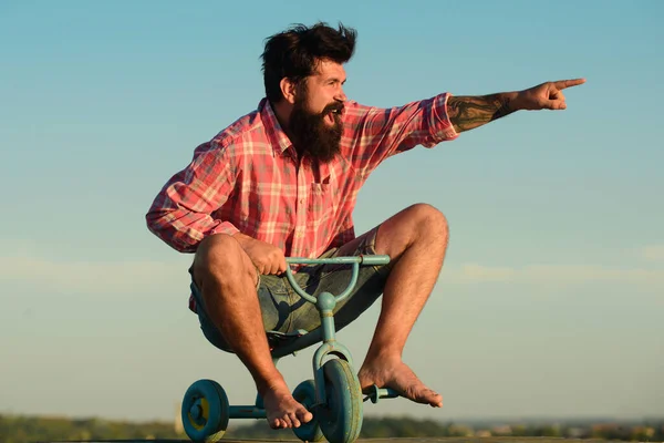 Crazy man riding a small bicycle. Excited young male riding a small bicycle and gesturing happiness. Young man riding three wheeled bicycle. — Stock Photo, Image