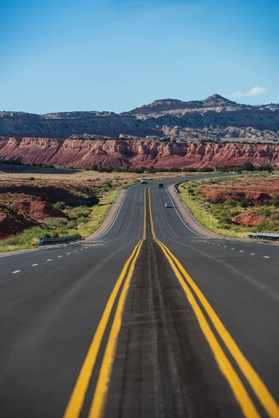 Klassischer Panoramablick auf eine endlos gerade Straße, die durch die karge Landschaft des amerikanischen Südwestens führt. — Stockfoto