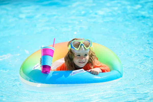 Child swims and dives in the pool. Cute funny little toddler boy in a colorful swimming suit relaxing with toy ring floating in a pool. Summer kids vacation in a tropical resort. — Stock Photo, Image