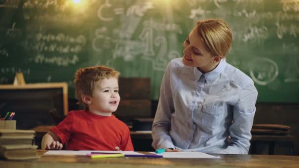 Moeder en kind zoon op de basisschool. Kleuterschoolkinderen. Leraar en kind hebben plezier op het leren in een school. — Stockvideo