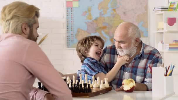 Pai, avô e filho a jogar xadrez em casa. Jogos e atividades para crianças. Conceito familiar. Jogos educativos. — Vídeo de Stock