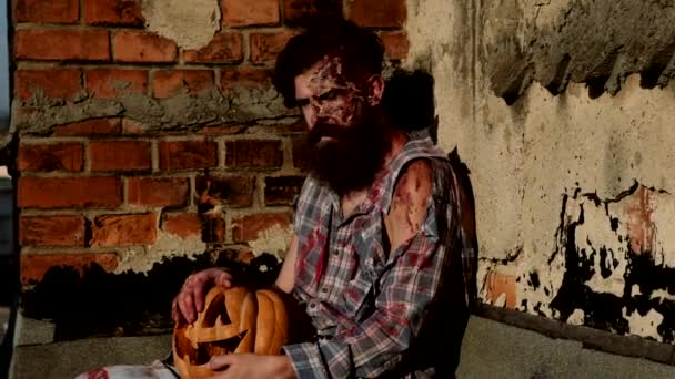 Male zombie with pumpkin looking at camera. Halloween theme. — Stock Video