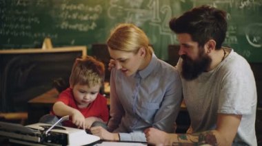 Erken çocukluk eğitimi. Öğretmenler günü. Aile çalışması. Ebeveynler, çocuklarına ev ödevlerinde yardım ediyorlar. Baba, anne ve oğul öğreniyor. Çocuk eğitimi. Küçük zeki dahi..