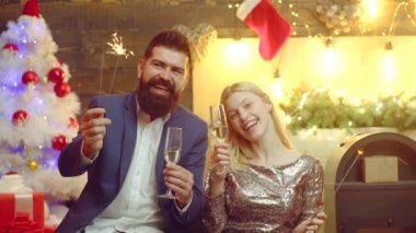 Mutlu noeller. Genç çift şampanya içip Noel 'i ya da evde yeni yılı kutluyor..