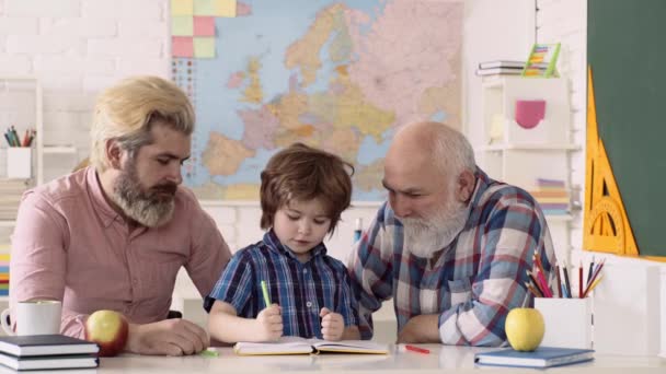 Lindo niño y maestros de escuela primaria. Niños de escuela privada. Padre e hijo con abuelo aprendiendo en la escuela primaria. Los hombres estudian en interiores. — Vídeos de Stock