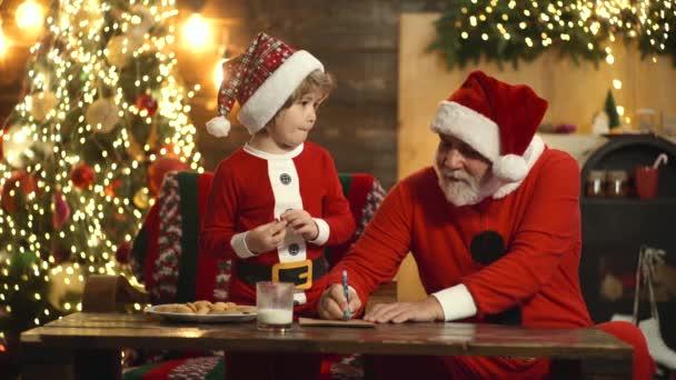 Retrato de padre viejo y niño escribiendo carta a Santa Claus. Ayudante de Navidad leyendo la lista de deseos. Abuelo con niño pequeño preparar Navidad y Año Nuevo. — Vídeos de Stock