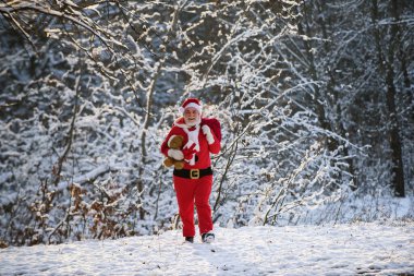 Noel baba hediyeler dağıtır. Noel giysileri içinde Noel Baba, karlı kış dağında.