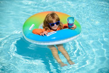 Yüzme havuzunda yüzme halkasıyla oynayan mutlu çocuk. Yaz tatili. Sağlıklı çocuk yaşam tarzı.