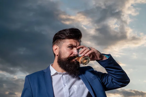 Mann mit Bart hält Glasschnaps in der Hand. Bartträger trinken Cognac. Mann mit einem Glas Whisky. Whisky schlürfen. Porträt eines Mannes mit dickem Bart. Degustation, Verkostung. — Stockfoto