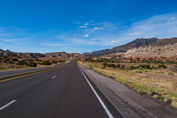 Rural asphalt road among the fields in summer season.
