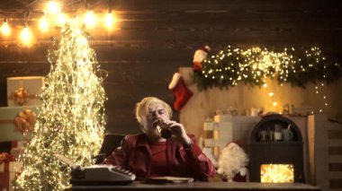 Sarhoş, kötü Noel Baba. Yalnız arkadaşsız Noel tatili konsepti. Üzgün genç erkek Noel ağacında bira içiyor..