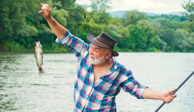 Balık tutmaya. Nehirde oltayla balık tutan yakışıklı bir balıkçı. İnsan balıkçı balık yakalar..