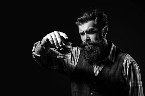 Mężczyzna lub biznesmen pije whiskey na czarnym tle. Z brodą i szklanką whisky. Napoje alkoholowe. — Zdjęcie stockowe