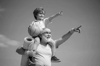 Fitness ve aktif yaşam tarzı konsepti - fotokopi alanı. Aktif aile spor ve spor yapmayı sever. Çocuklar için spor egzersizi. Dedem çocuğun egzersiz yapmasına yardım ediyor..