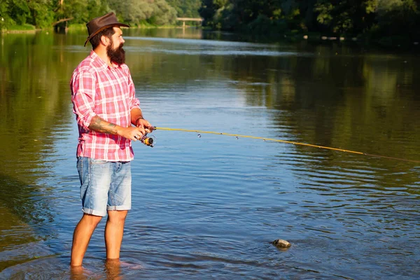 Der Mensch fischt. Fliegenfischer mit Fliegenrute im schönen Fluss. Mann mit Angelruten am Liegeplatz im Fluss. Konzepte erfolgreicher Fischerei. — Stockfoto