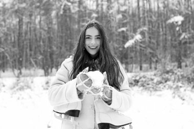 Kar yağan kış güzellik moda konsepti. Kışın giyinmiş kadınlar. Açık havada, uzun saçlı güzel bir kızın portresini yakın çekiyoruz..