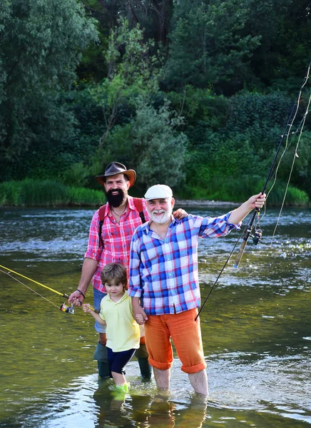 Pesca. Padre, figlio e nonno in battuta di pesca. Pesca nel fiume. Nonno con figlio e nipote che si divertono nel fiume. Felice giorno dei padri. — Foto Stock