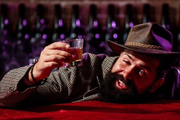 可笑的大胡子酒后嬉皮士拿着玻璃杯威士忌. — 图库照片