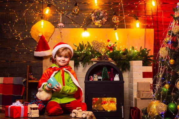 Wesołych Świąt i szczęśliwego Nowego Roku. Święta Bożego Narodzenia. Prezenty i niespodzianki. Cute little boy bawić się w pobliżu choinki. Dzieciak lubi zimowe wakacje w domu. Dom pełen radości i miłości — Zdjęcie stockowe