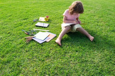 Çocuk parkta eğitim için kitap okuyor. Ev dışında öğrenim.