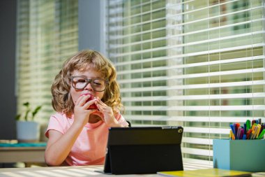 Çocuk eğitimi, bilgi. Öğrenci evde aldığı online derste matematik okuyor, karantina sırasındaki sosyal mesafe, kendini izole etme, online eğitim konsepti.