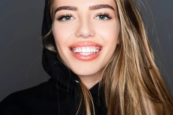 Rapariga sorridente, cara de perto. Retrato de moda de beleza. Sorrindo jovem mulher em cinza. — Fotografia de Stock