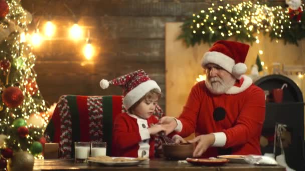 Papai Noel com criança ajudante preparar Natal ou Ano Novo, biscoitos assados. — Vídeo de Stock