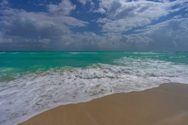 Deniz dalgaları arka planı. Yaz turizmi. Okyanus suyu hareketi. Okyanus sıçrama dalgası arka planı. Derin mavi deniz plajı. Turkuaz dalga. Rüya gibi egzotik deniz plajı. Güzel deniz dalgaları