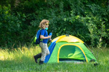 Çocuk yazın pikniğin tadını çıkarıyor. Kamp yapan çocuk eğlencesi. Doğada küçük bir turist. Çocuk yaz kampında eğleniyor. Doğayı keşfeden bir çocuk. Kamp gezisindeki mutlu çocuk. Çocuklarla piknik