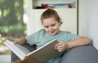 Evde kitap okuyan bir çocuk. Çocuk kitabı okuyorum. Çocuk kapalı mekanda kitap açıyor. Çocuk kitaplarla kazanıyor. Çocuk ders kitaplarına odaklanmış. Akıllı öğrenci masal kitabı okuyor. Çocuk masada kitap okuyor.