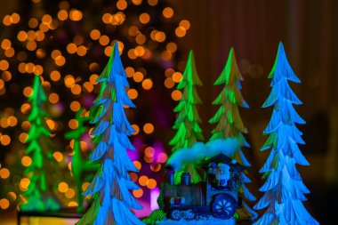 Noel Baba, Yeni Yıl, Noel kartı. Noel ağacı arka planında Noel Baba. Noel ağacı. Yeni yıl için Noel süslemeleri. Trendeki Noel Baba. Noel Baba 'yla yeni yıl geçmişi