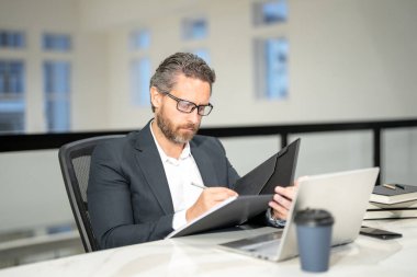 Modern ofis. İşletme takımında başarılı bir beyaz iş adamı dizüstü bilgisayar kullanıyor, uzaktan kumandayla çalışıyor, e-ticaret yapıyor. Finans denetçisi. Yönetim kurulu başkanının iş fikri var. Girişim