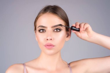 Koyu kaşlı güzel bir kadın kaş fırçası tutuyor. Kaş kaplaması. Güzellik prosedürlerini uygula. Kaş ve kaş çizgisi, kaş çizgisi.